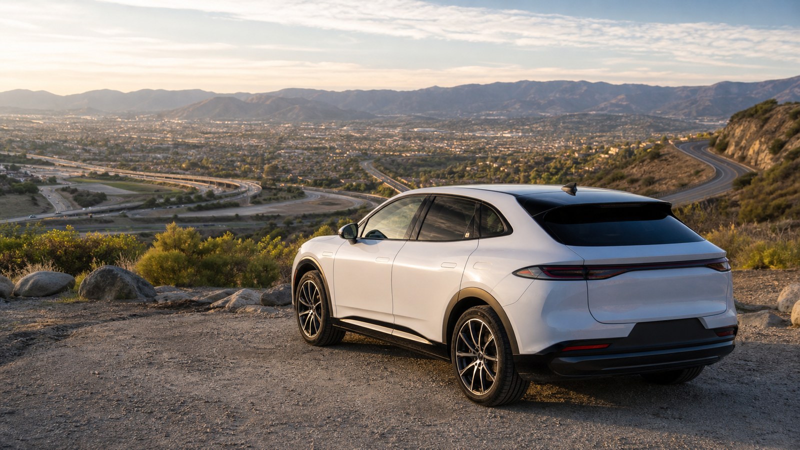 Electric vehicle overlooking varied roads and terrain that affect driving range